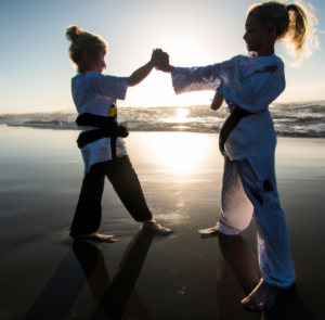 two kids training jiu jitsu on the beach